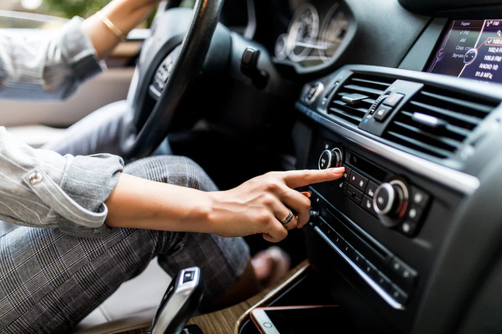 Warranties & Insurance perth page - car-dashboard-radio-closeup-woman-sets-up-radio-while-driving-car