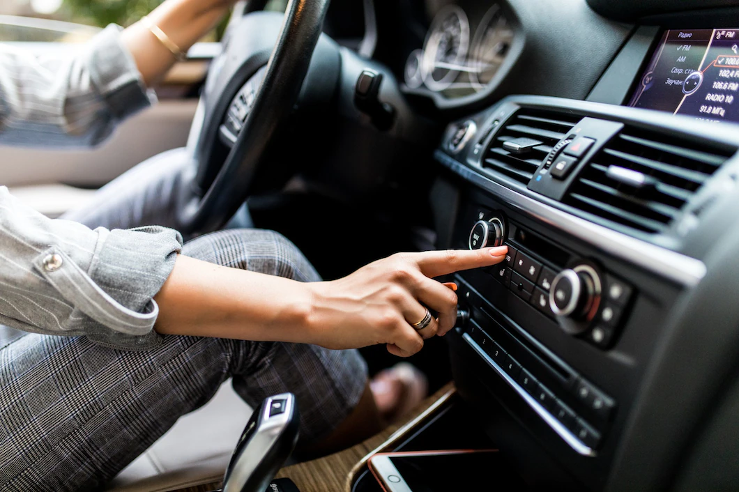 Car dashboard - woman sets up radio while driving car - car financing