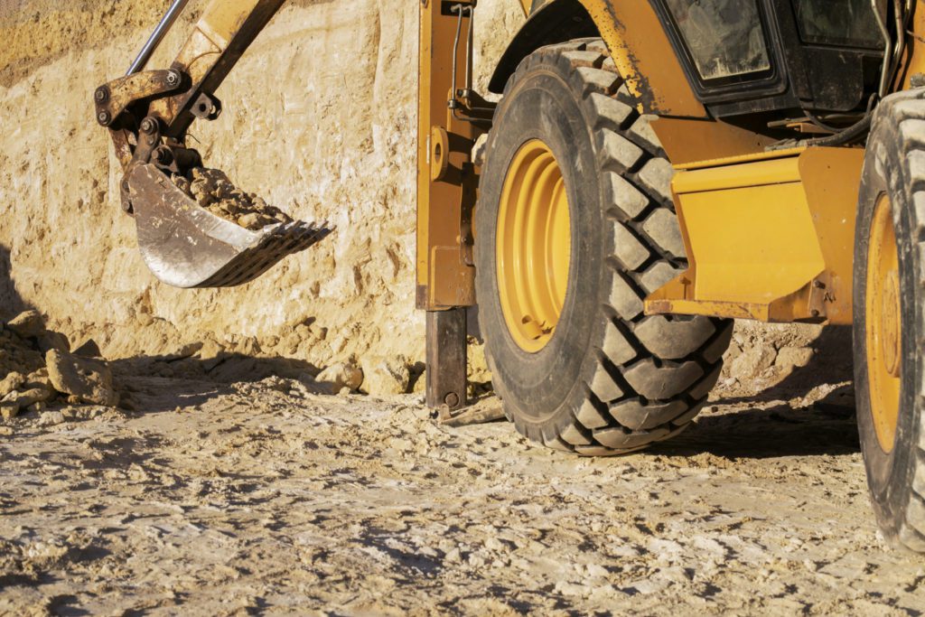 excavator digging ground on daylight - machinery finance